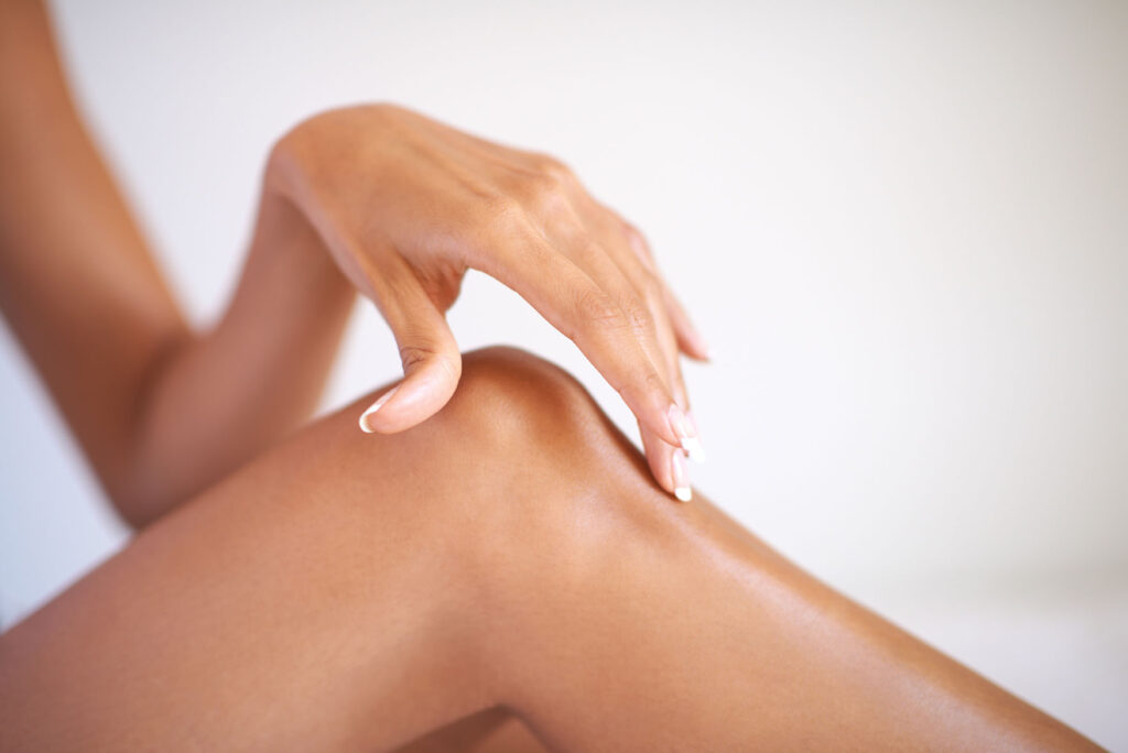 close-up of a person’s hand gently touching their leg near the knee
