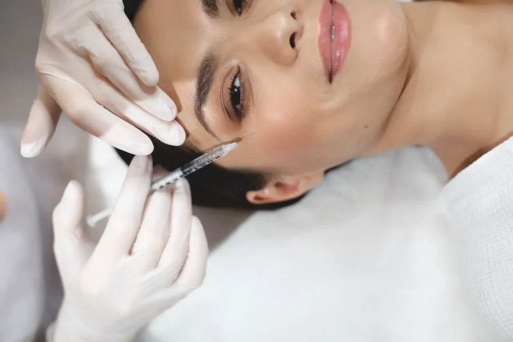 practitioner performing Botox injection near eye area for wrinkle reduction